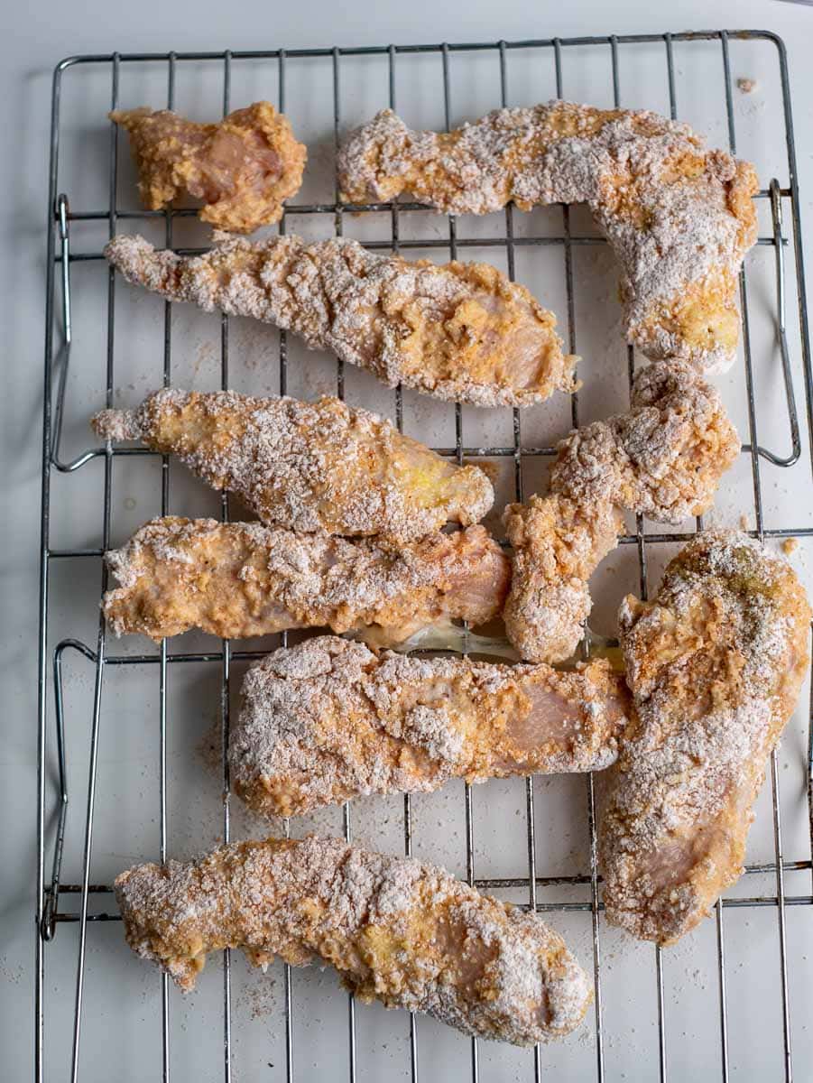 Fried chicken wings on a cooling rack.