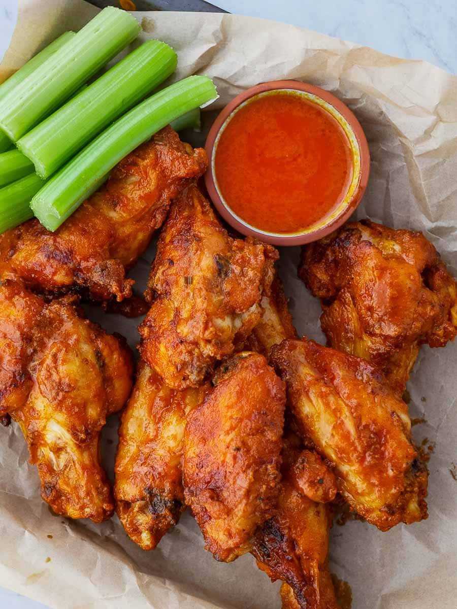Bbq chicken wings with celery and dipping sauce.