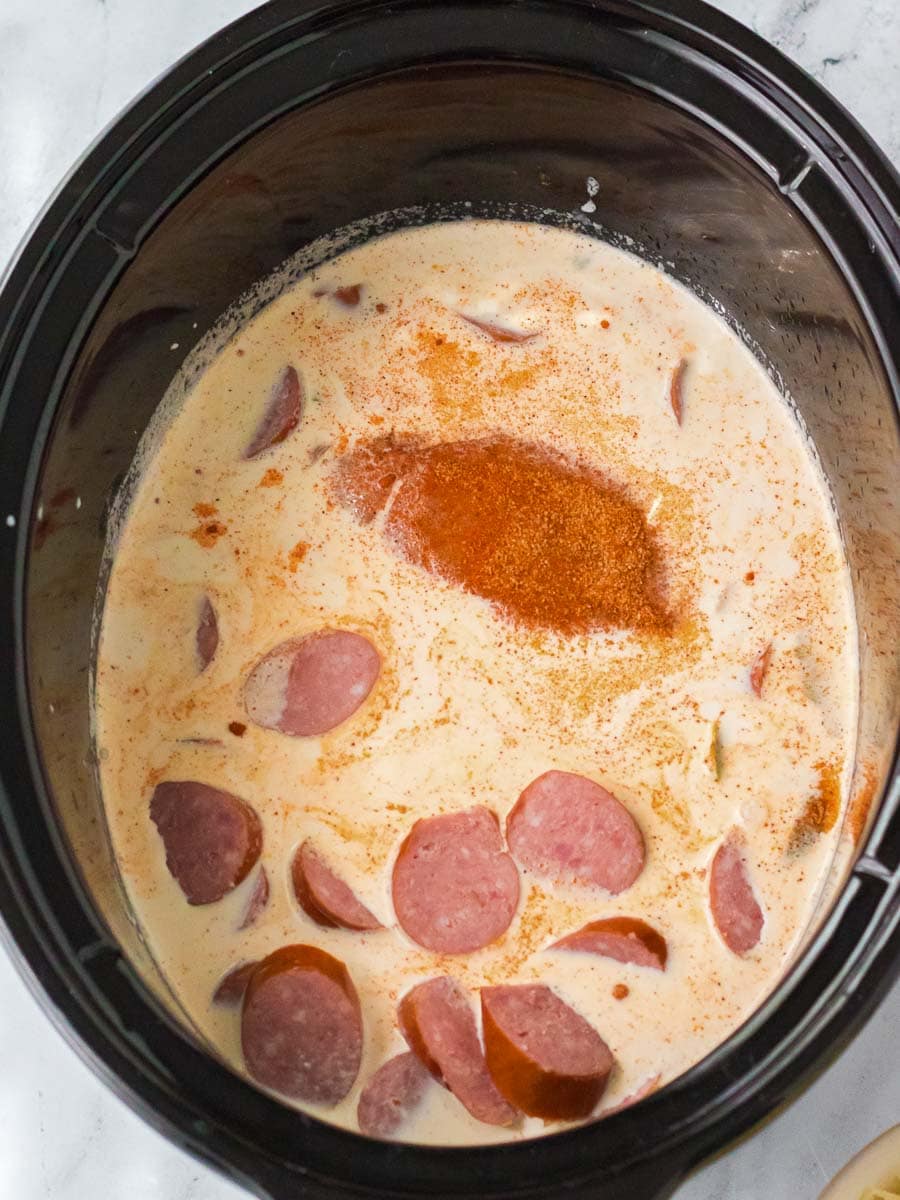 A crock pot filled with sausage and gravy.