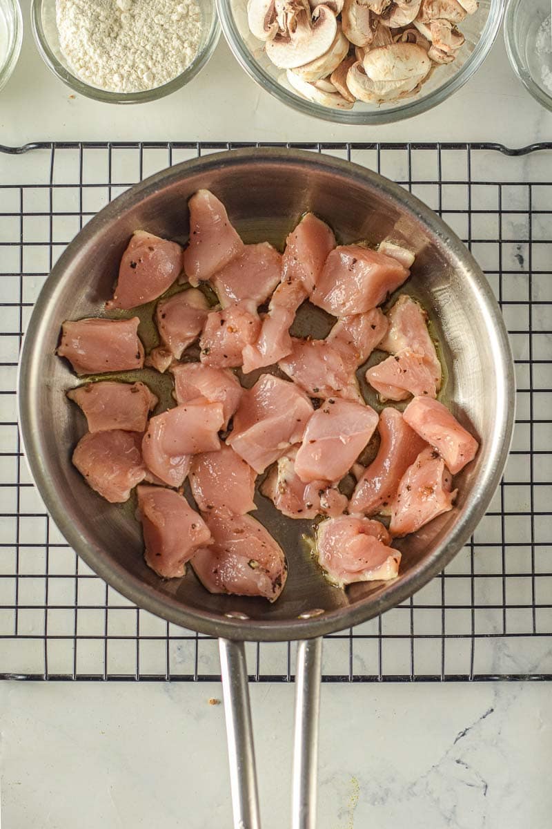 A pan of raw chicken on a cooling rack.