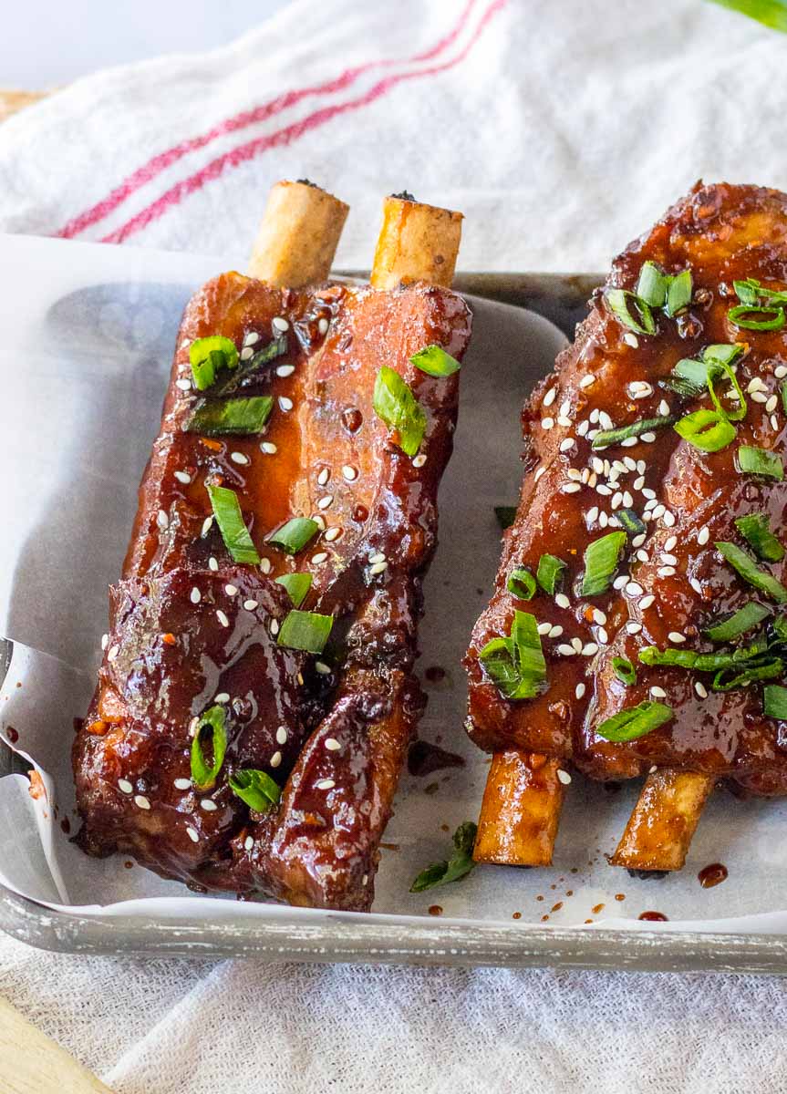 Asian ribs on a baking sheet with sesame seeds.