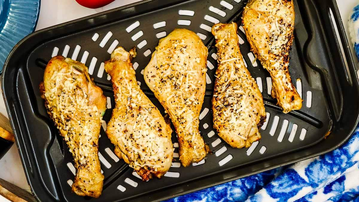 A tray of chicken legs on a blue tablecloth.