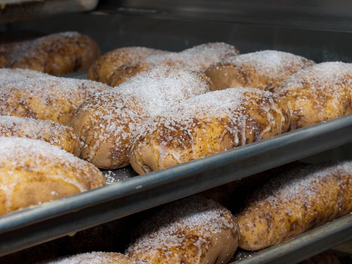 A tray of baked goods covered in powdered sugar.