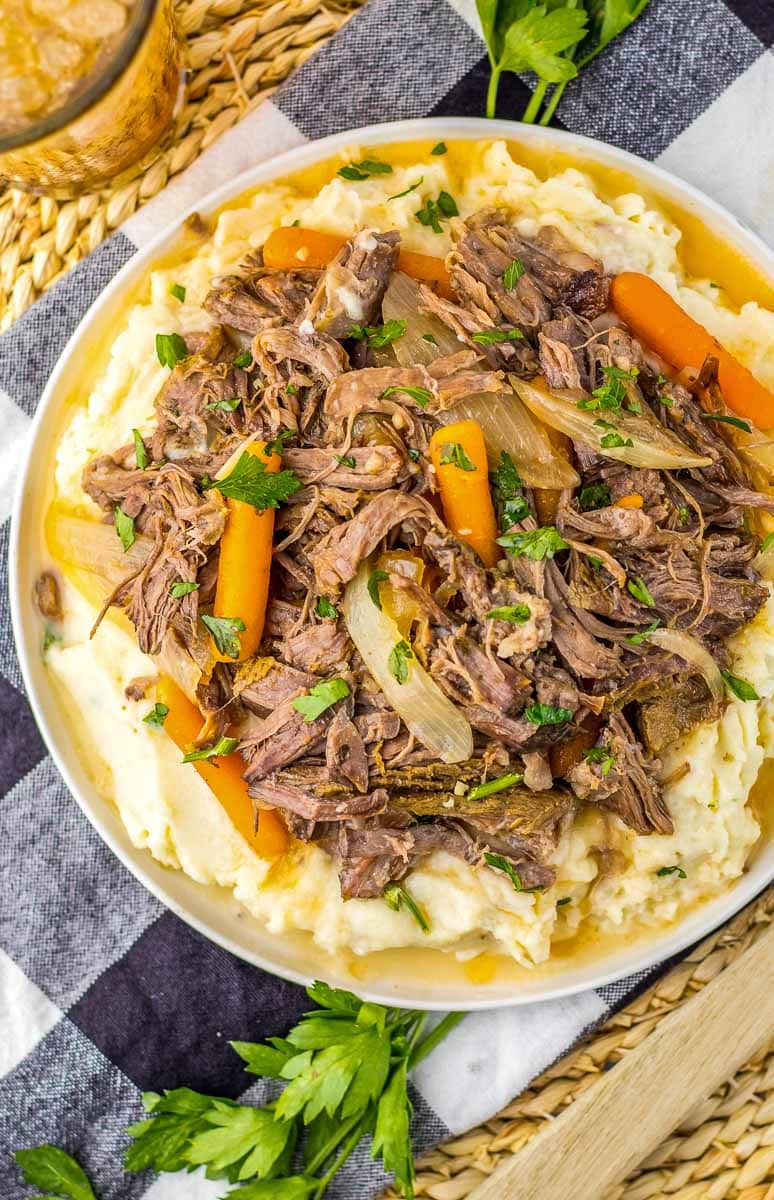 A flavorful plate of slow cooker beef and mashed potatoes with gravy, featuring tender chuck roast.