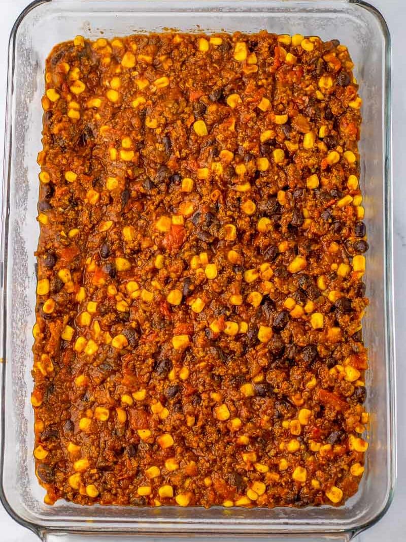A casserole dish filled with chili cornbread casserole ingredients.