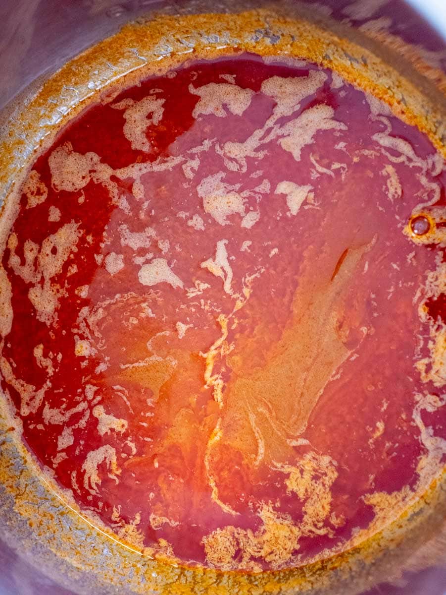 A close up of a red liquid in a pot.