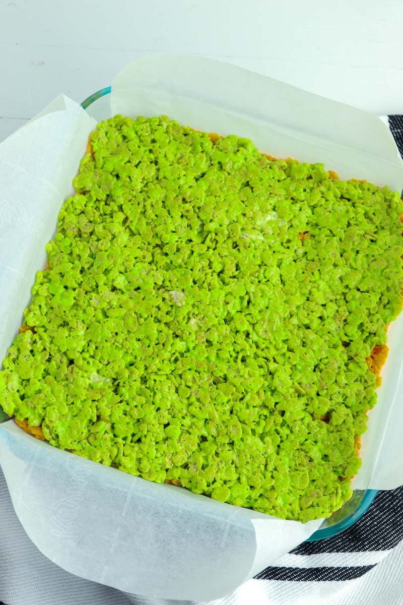 A baking dish filled with green rice krispy treats.