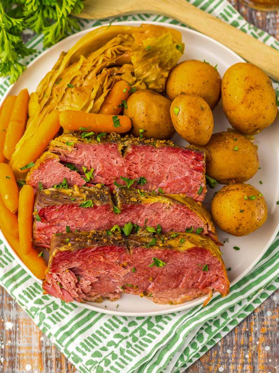 A plate of corned beef, carrots and potatoes.