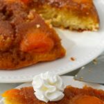 Sliced Apricot Upside Down Cake served on plates with a dollop of whipped cream.