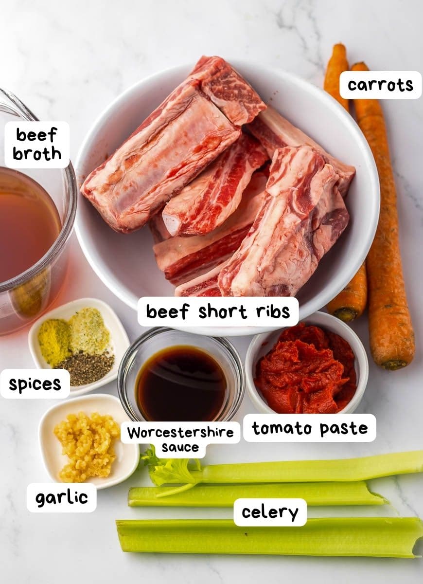 A bowl of ingredients for beef ribs with vegetables.