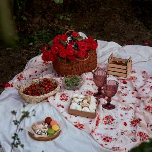 Aesthetic Picnic: A picnic in the woods with a basket of flowers and desserts.