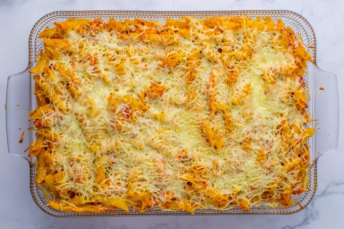 Baked pasta dish topped with melted cheese in a glass dish.