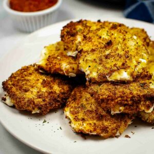 Golden-brown fried mozzarella served on a white plate.