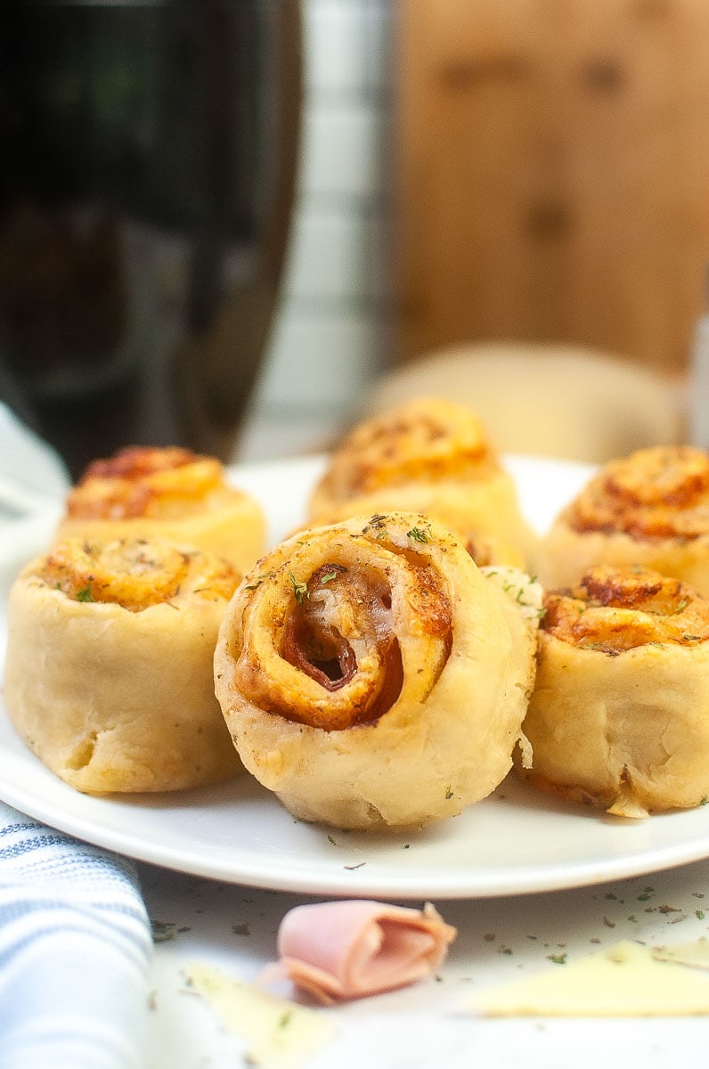 A plate of freshly baked pizza rolls garnished with herbs.