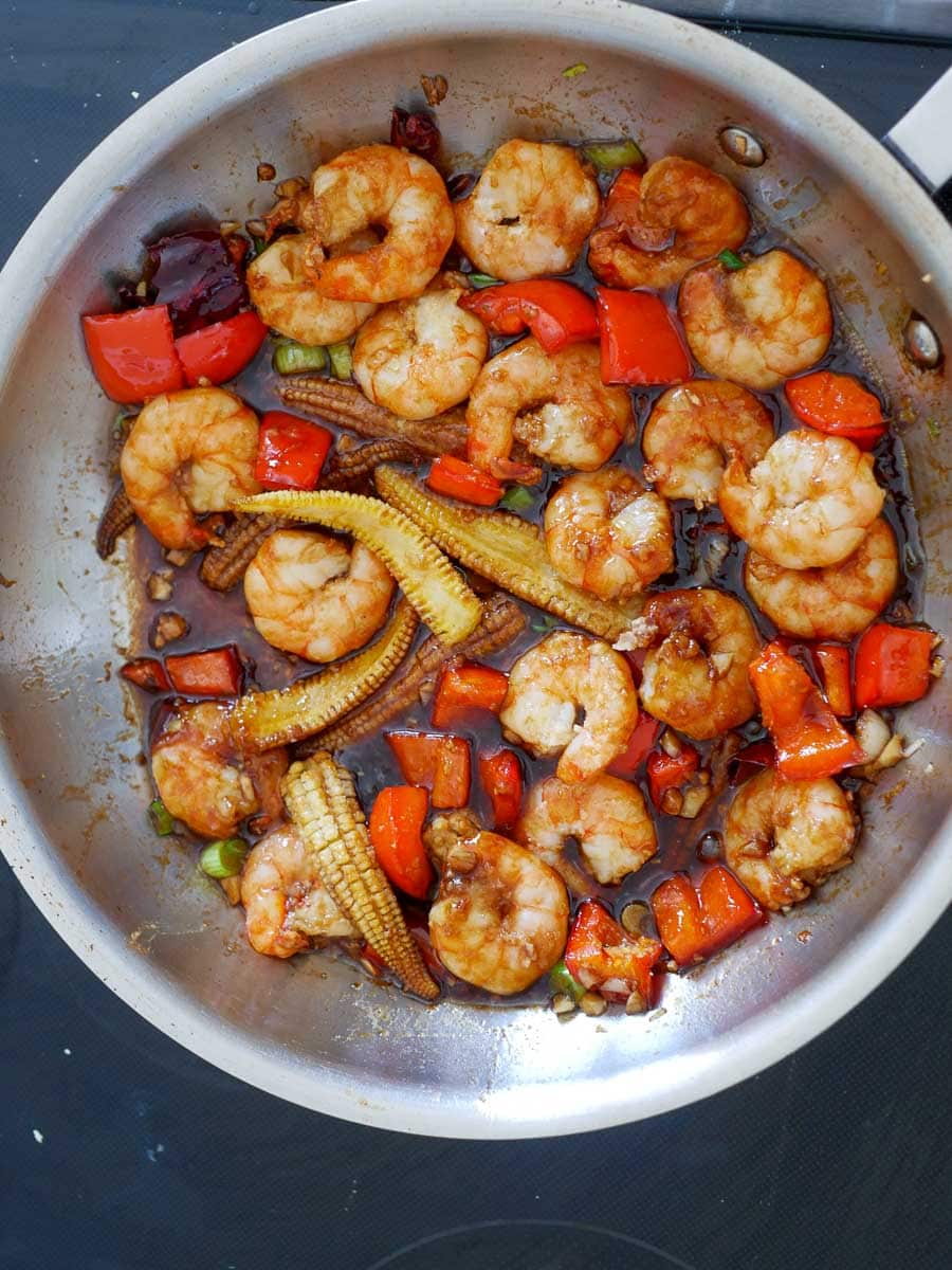 Cooked shrimp with vegetables in a pan.