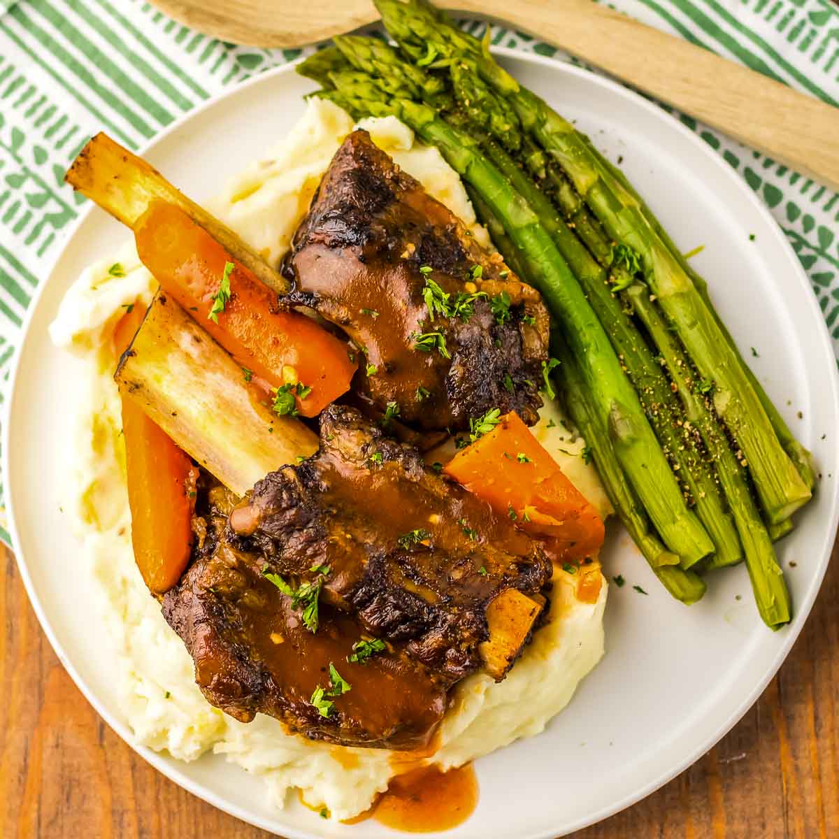 A slow cooker full of short ribs and vegetables.
