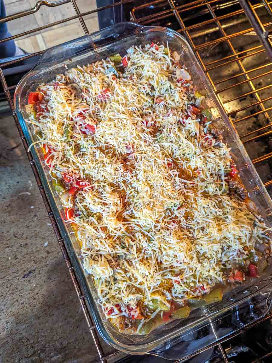 A stuffed bell pepper casserole is being cooked in an oven.