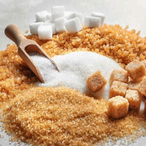 Various types of sugar including white granulated sugar, brown sugar cubes, and raw cane sugar with a wooden scoop.