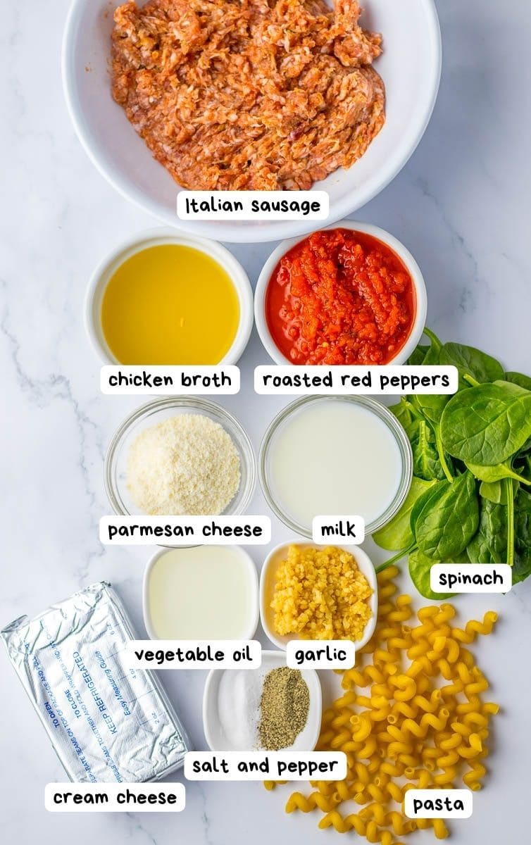 Various ingredients for making a pasta dish, including italian sausage, roasted red peppers, spinach, and cheese, neatly displayed and labeled.