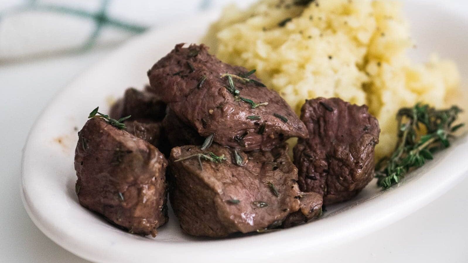 steak bites on a plate with potatoes