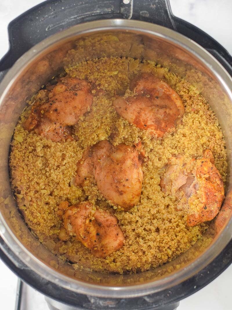 Moroccan chicken thighs cooked with quinoa inside an instant pot, viewed from above.