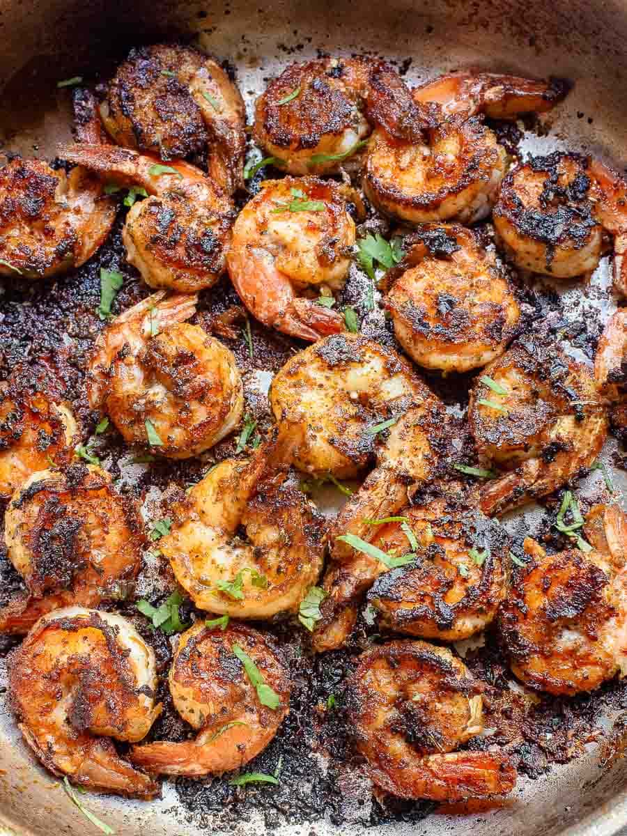 Pan-seared shrimp with seasoning and char marks in a skillet, ready to be served.