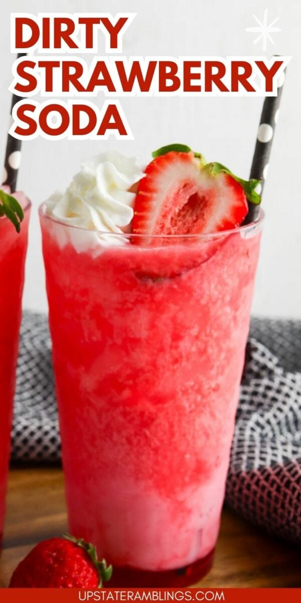 Bright pink strawberry soda topped with whipped cream and a sliced strawberry, served in a tall glass with a black and white striped straw. Text overlay reads "Dirty Strawberry Soda.