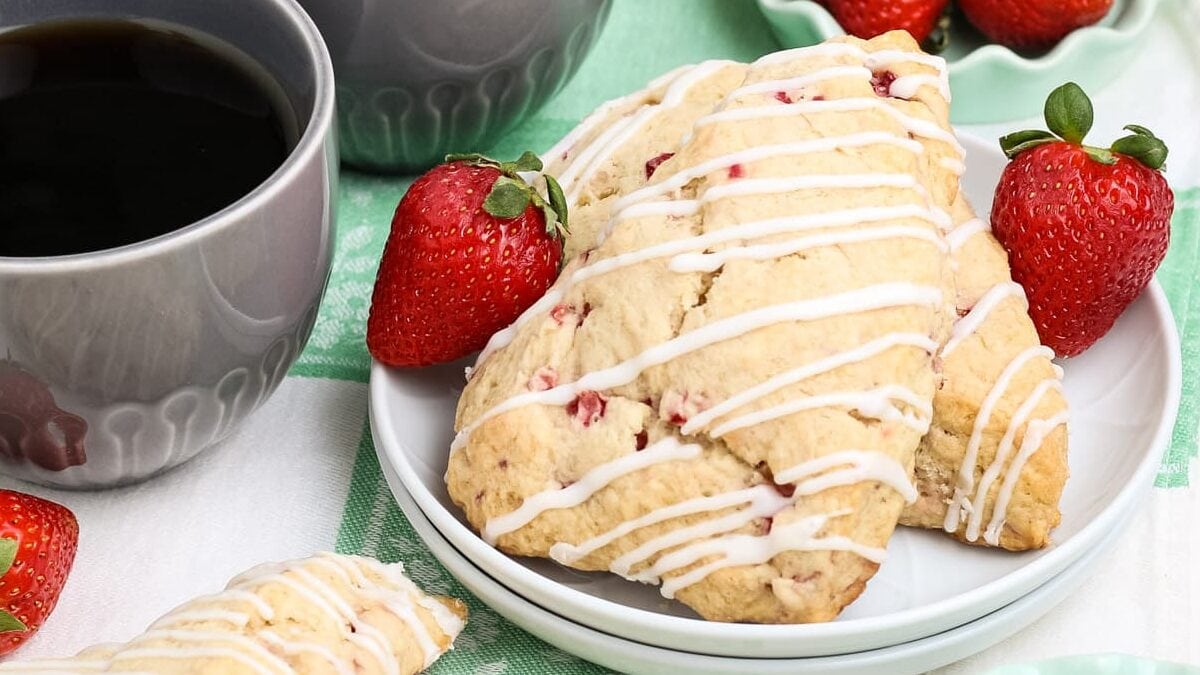 Strawberry scones on a plate with coffee on the side.