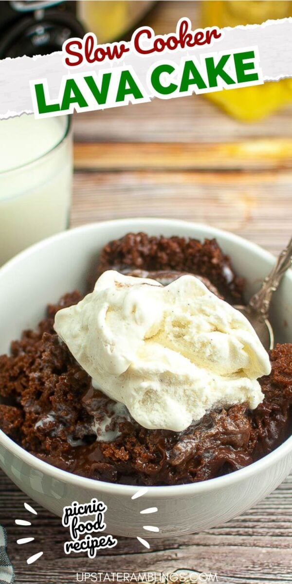 A bowl of slow cooker chocolate lava cake topped with a scoop of vanilla ice cream, with a spoon in the bowl and a glass of milk in the background.