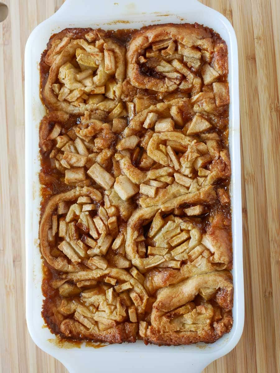 A baked apple dessert in a rectangular dish featuring swirled pastry and sliced apples on top.