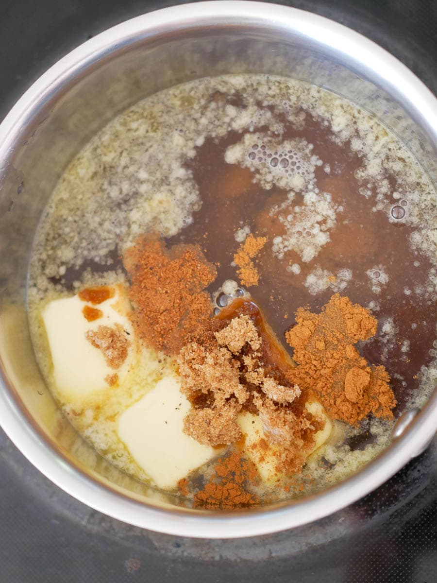 Butter, brown sugar, and spices melting together in a saucepan.