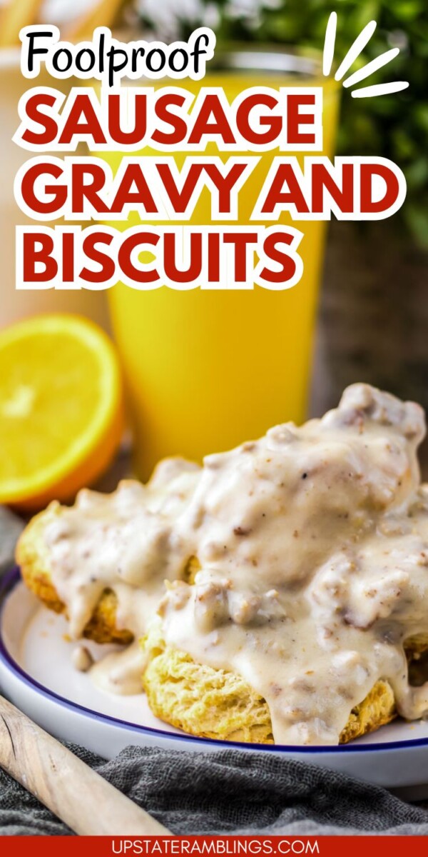 Plate of biscuits topped with sausage gravy, next to a sliced lemon and a glass of orange juice.