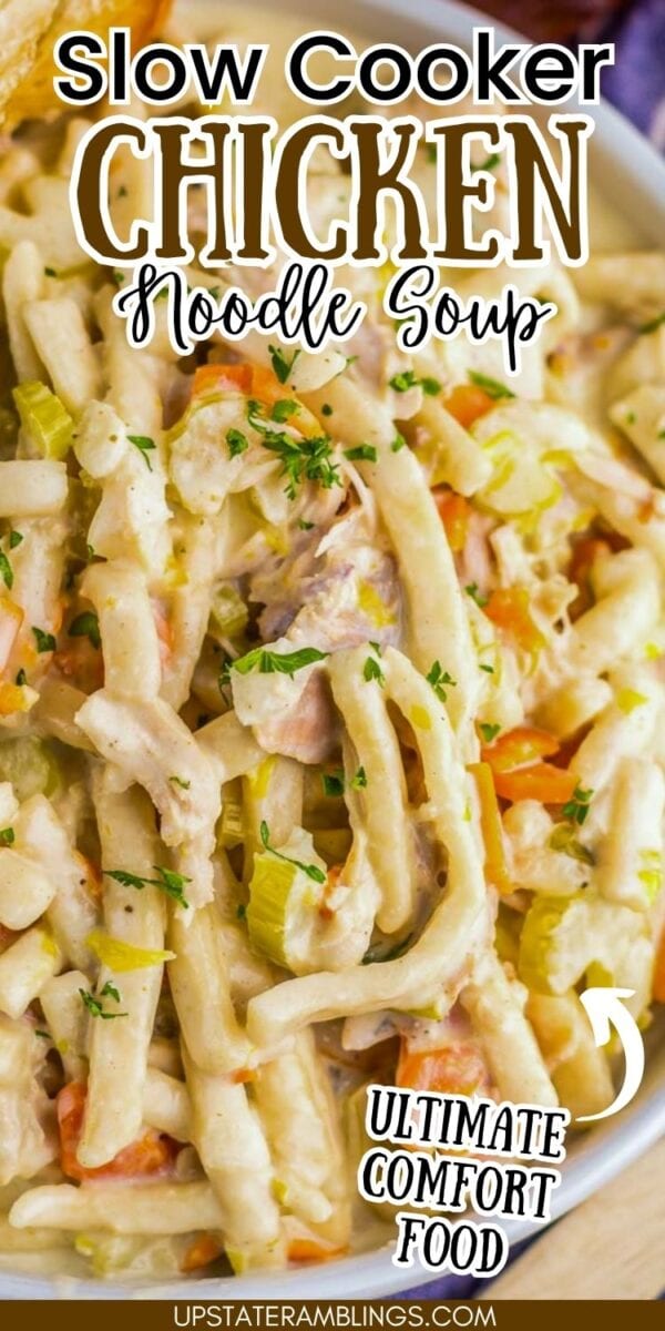 Close-up of creamy chicken noodle soup made in a slow cooker with chopped vegetables and herbs, topped with parsley. Text overlay reads "Slow Cooker Chicken Noodle Soup, Ultimate Comfort Food.
