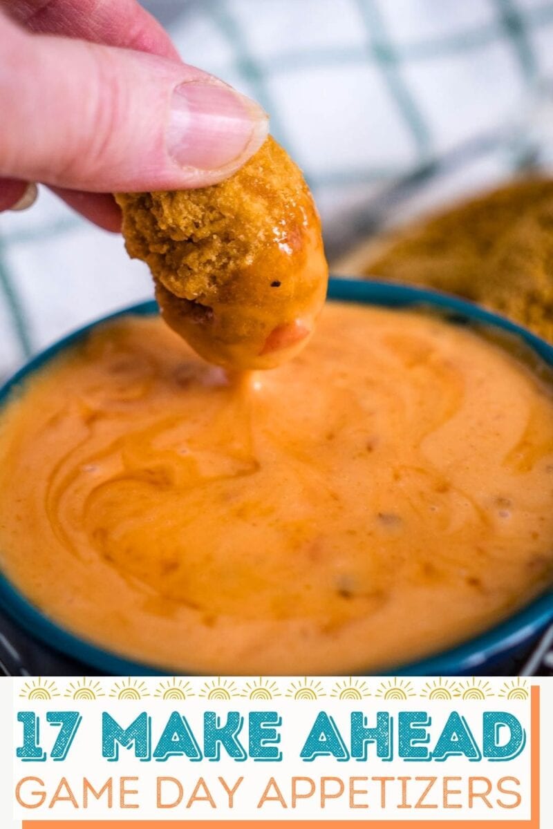 A hand dips a breaded appetizer into a bowl of orange cheese sauce; text below reads “17 Make Ahead Game Day Appetizers.”.