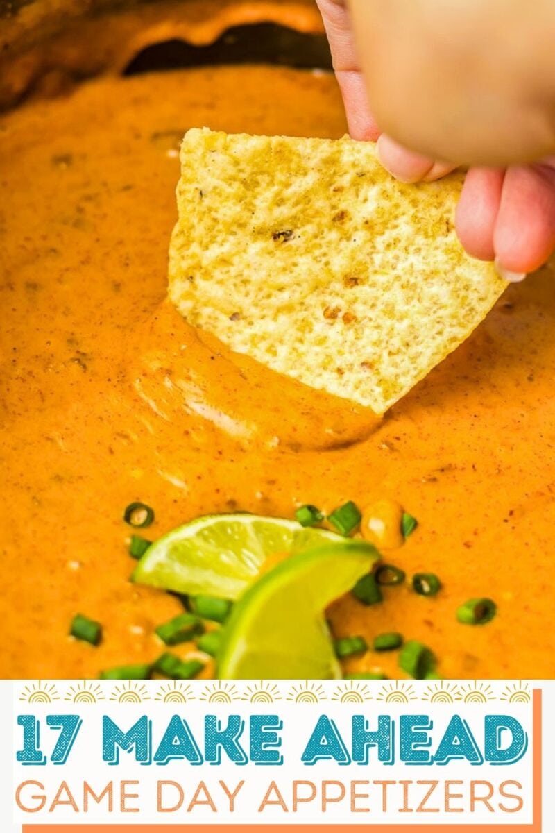 A hand dips a tortilla chip into cheesy dip garnished with green onions and a lime wedge. Text at bottom reads, “17 Make Ahead Game Day Appetizers.”.